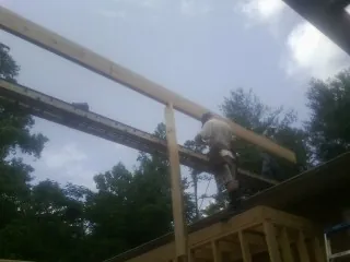 Carpenter setting a ridge beam over a new addition frame — Ice Dam Removal by Roofing Brothers in Lake Park