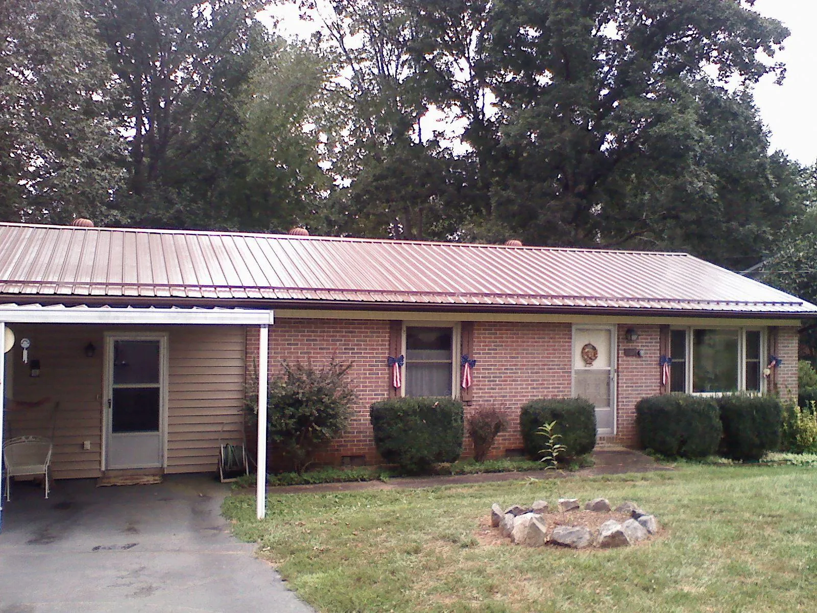 Bronze metal roof and carport on a brick ranch home — Roof Repair work by our crew in Lake Park